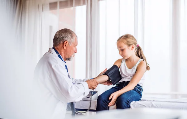 Senior doctor checking a small girl in his office. — Stock Photo, Image