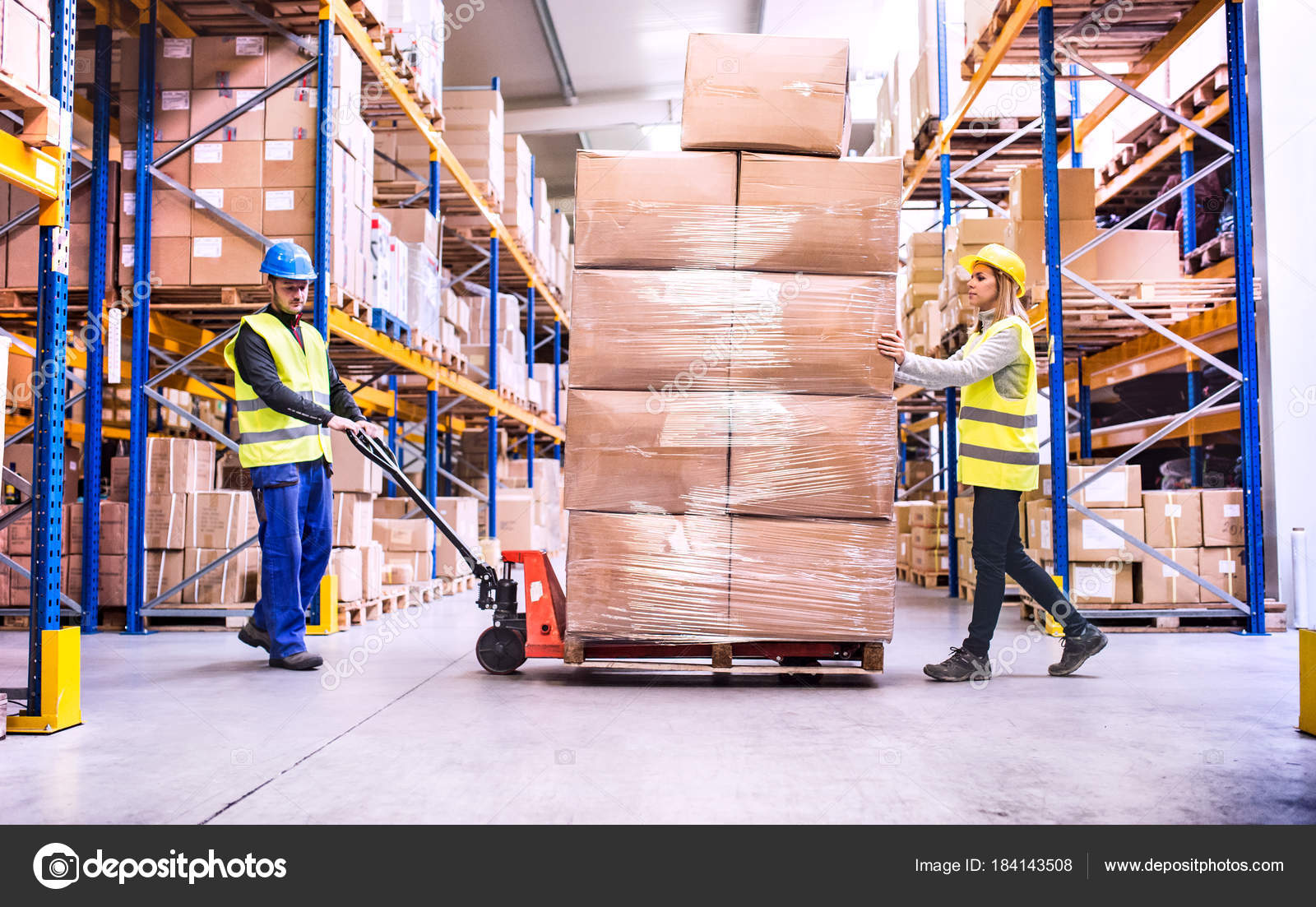 Warehouse workers pulling a pallet truck. — Stock Photo © halfpoint