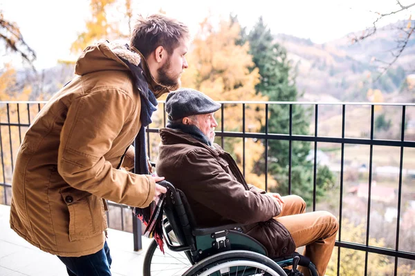 Senior Vater im Rollstuhl und kleiner Sohn auf Spaziergang. — Stockfoto