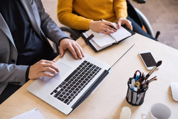 Zwei Geschäftsleute mit Rollstuhl im Büro. — Stockfoto