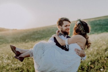 Güzel gelin ve damat yeşil doğa gün batımında.