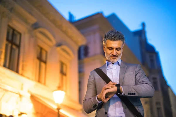 Rijpe zakenman met een smartwatch in een stad. — Stockfoto