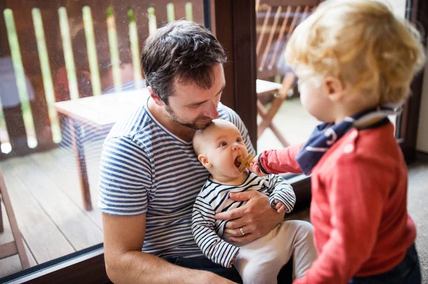 Padre con un niño pequeño y un bebé en un hotel . — Foto de Stock