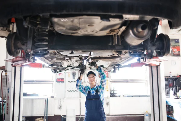 Portrait of a senior female mechanic in a garage. — Stock Photo, Image