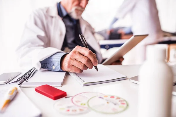 Médico sênior com tablet em seu escritório . — Fotografia de Stock