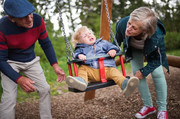 遊び場で男の子とシニア カップル. — ストック写真