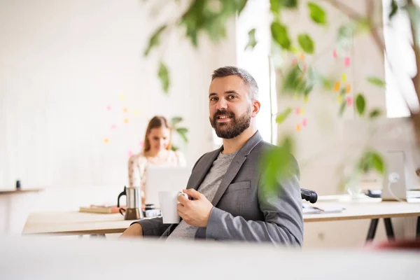 Två affärsmän med rullstol på kontoret. — Stockfoto