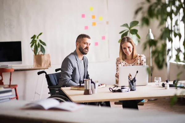 Two business people with wheelchair in the office. — Stock Photo, Image