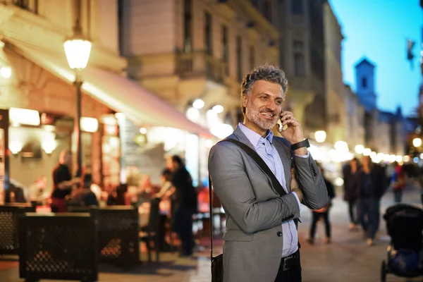 Hombre de negocios maduro con un smartphone en una ciudad . —  Fotos de Stock