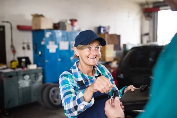 Starszy Mechanik kobiece naprawy samochodu w garażu. — Zdjęcie stockowe