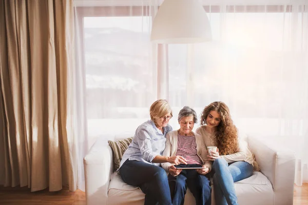Una ragazza adolescente, madre e nonna con tablet a casa . — Foto Stock