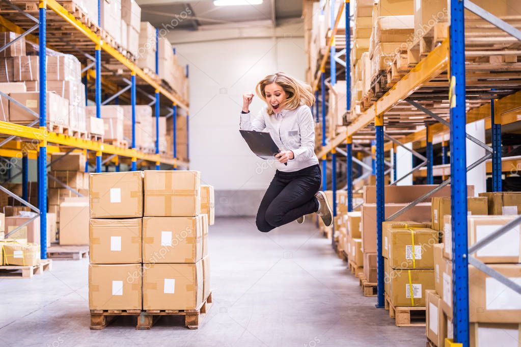 Overjoyed female worker or supervisor in a warehouse.