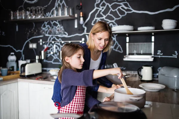 Malá holčička se svou matkou doma vaření. — Stock fotografie