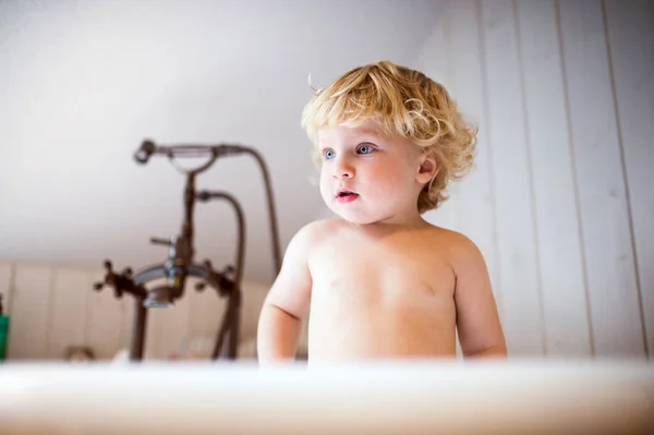 Banyoda küvette duran sevimli yürümeye başlayan çocuk. — Stok fotoğraf