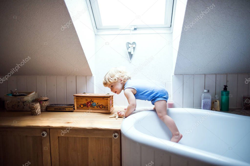 Toddler boy in a dangerous situation in the bathroom.