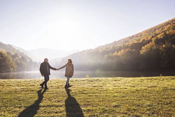 Äldre par på promenad i höstens natur. — Stockfoto