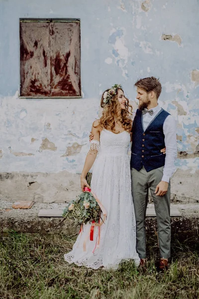 Bela noiva e noivo na frente da velha casa miserável . — Fotografia de Stock