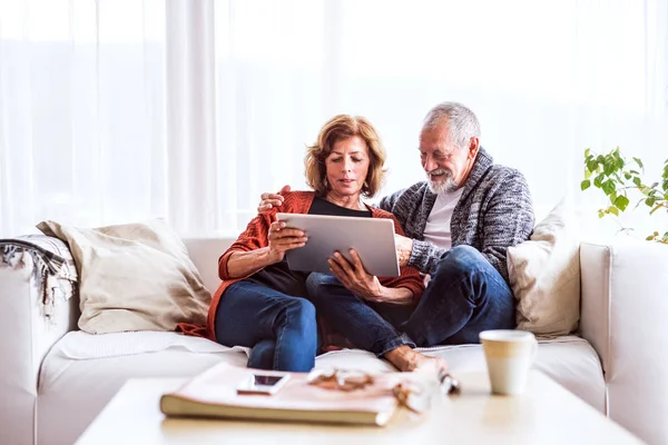 Senior couple with tablet relaxing at home. — Stock Photo, Image