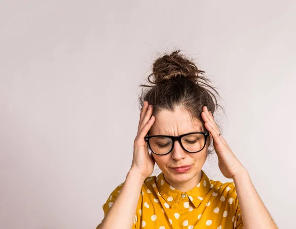 Portret van een jonge mooie vrouw met bril in studio. — Stockfoto