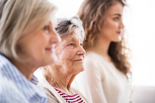 Een tienermeisje met moeder en grootmoeder thuis. — Stockfoto