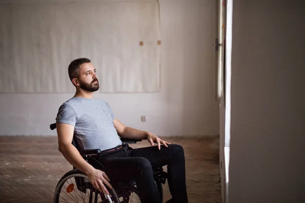 Adam tekerlekli sandalyeye mahkum pencereden dışarı bakıyor. — Stok fotoğraf