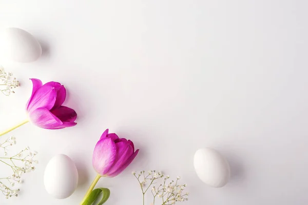 Λουλούδια και άσπρα αυγά σε λευκό φόντο. — Φωτογραφία Αρχείου