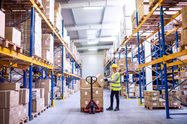 Magazijn van de vrouwelijke werknemer laden vakken. — Stockfoto