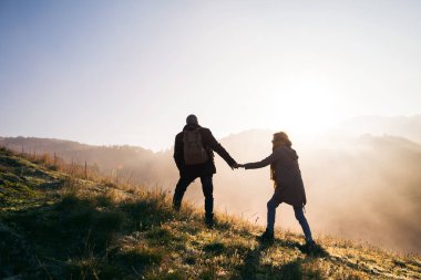 Sunrise adlı bir sonbahar doğada yürüyüşe üst düzey Çift.