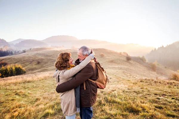 Casal sênior em um passeio em uma natureza de outono. — Fotografia de Stock