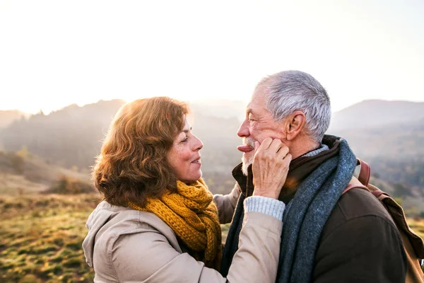 Seniorenpaar spaziert in herbstlicher Natur. — Stockfoto