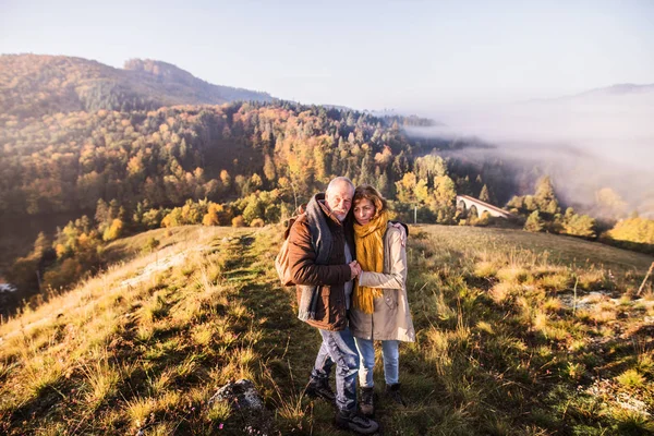Äldre par på promenad i höstens natur. — Stockfoto