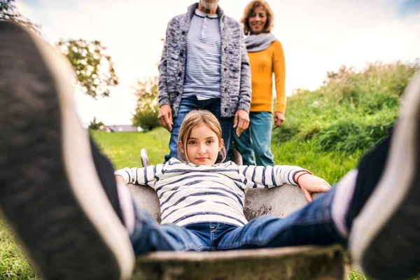 Senior couple with granddaughter gardening in the backyard garden. — Stock Photo, Image