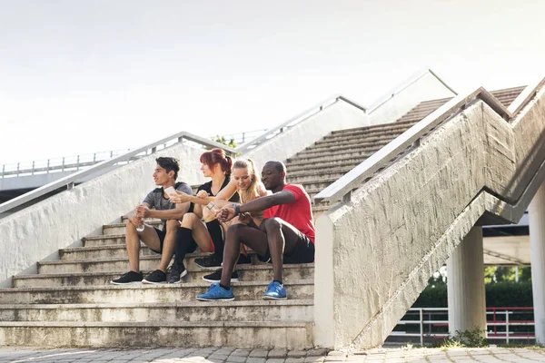 Young runners in the city sitting on the stairs. — Stock Photo, Image