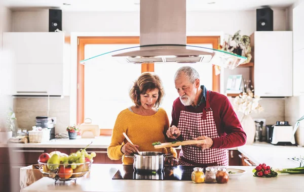 Senior para przygotowuje jedzenie w kuchni. — Zdjęcie stockowe