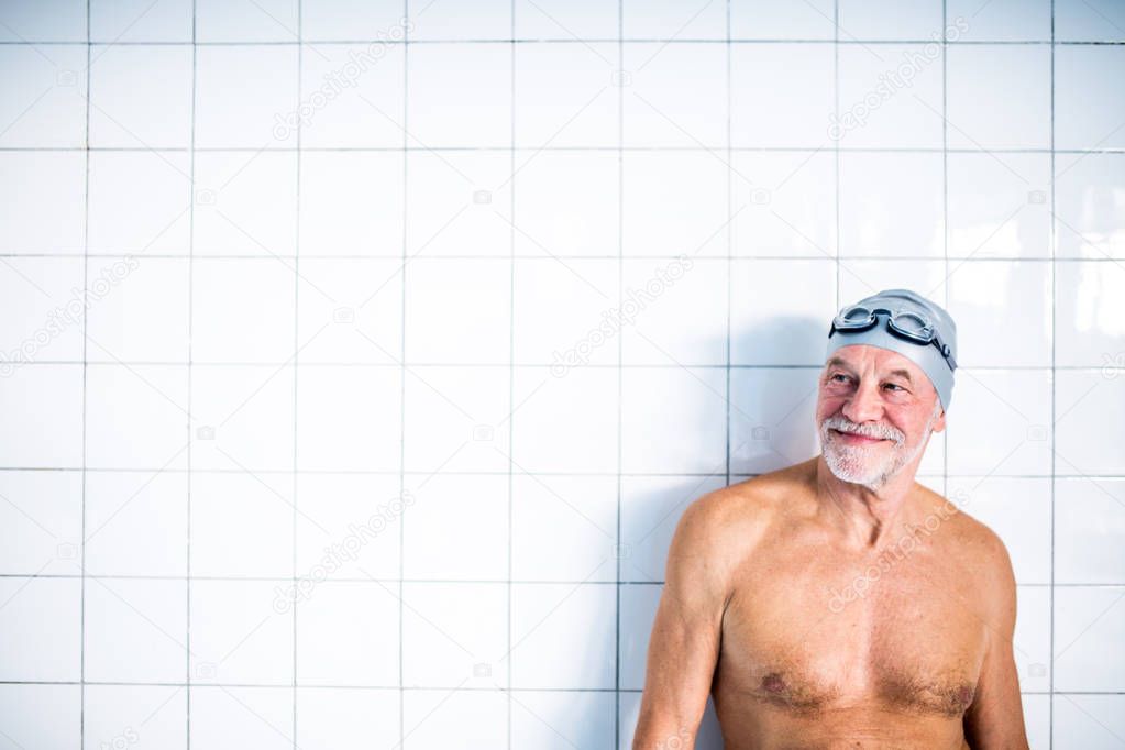 Portrait of a senior man in an indoor swimming pool.