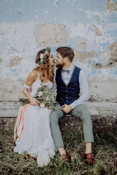 Schöne Braut und Bräutigam vor dem alten schäbigen Haus. — Stockfoto