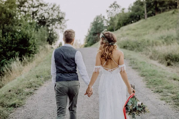 Mooie bruid en bruidegom in de groene natuur, hand in hand. — Stockfoto