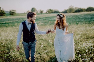 Güzel gelin ve damat yeşil doğa gün batımında.