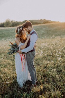 Güzel gelin ve damat yeşil doğa gün batımında.