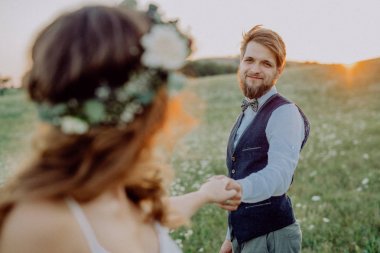 Güzel gelin ve damat yeşil doğa gün batımında.