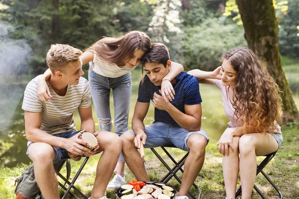 Adolescentes acampando na natureza, sentados na fogueira . — Fotografia de Stock