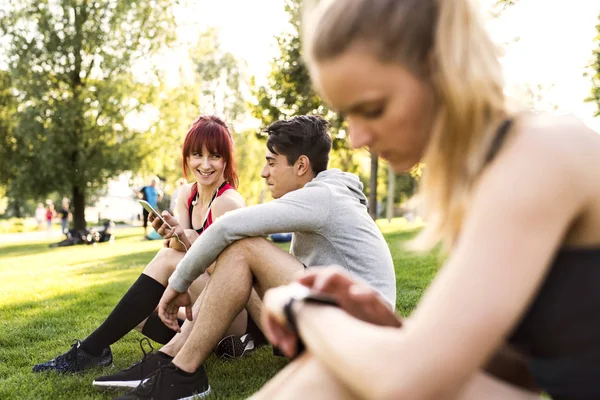 Groupe de jeunes coureurs se reposant dans un parc . — Photo