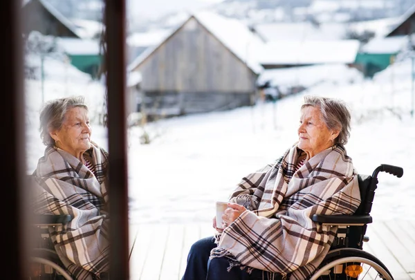 Старшая женщина на террасе зимой . — стоковое фото