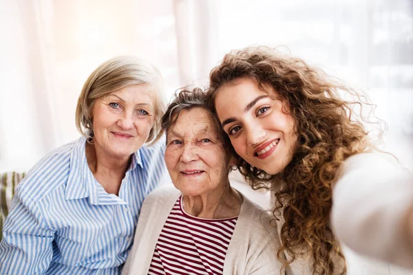 Ein Teenager-Mädchen mit Mutter und Großmutter zu Hause. — Stockfoto