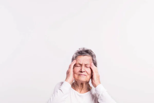 Studio portret van een senior vrouw in pijn. Kopiëren van ruimte. — Stockfoto