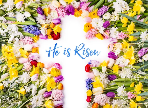 A cross on a colorful flower background. Easter flat lay. — Stock Photo, Image