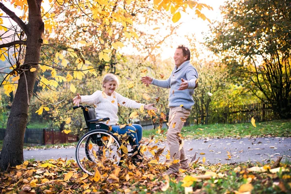 Couple sénior en fauteuil roulant en automne nature . — Photo