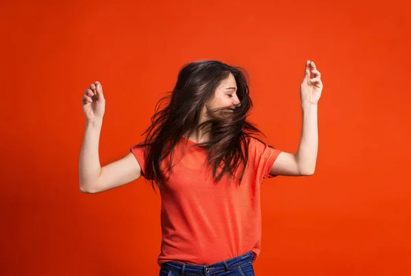 Uma jovem mulher em estúdio em um fundo vermelho . — Fotografia de Stock