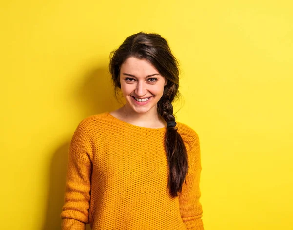 Młoda kobieta w studio na żółtym tle. — Zdjęcie stockowe