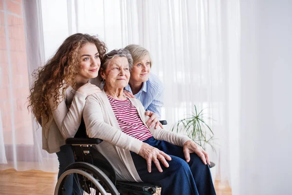 Девочка-подросток с матерью и бабушкой в инвалидном кресле дома . — стоковое фото
